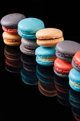 Assorted macaroons with flavorsome cream filling for all occasions. Confectionery photography concept in black background.