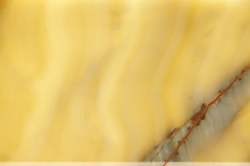 Yellow polished natural stone with a strip, backlit, called onyx