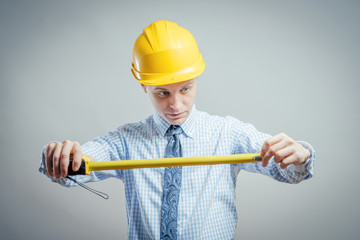 young builder with yellow tape measure