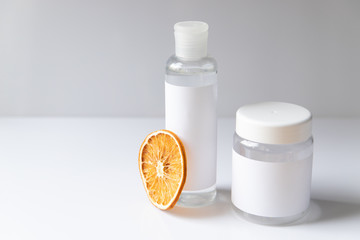 Cosmetic bottle for liquid, cream, gel, lotion. Hand sanitizer. Organic natural science beauty product. Battle with slice of orange