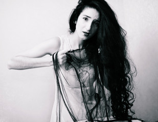 beauty girl cuting her hair in empty fearing room with cutted hair, halloween creepy celebration art