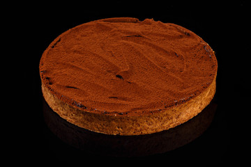 Chocolate Cheesecake. Whole cake. Art of sweets. Content for pastry shop and bakery. Traditional culinary. Black backdrop