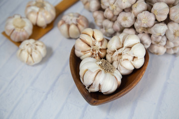 Garlic is placed on the white table in the kitchen, preparing for cooking,
Concept: The ingredients of vegetarian ingredients are very much about nature for good health, background  aromatic herbs 
