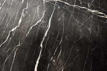 A slab of natural marble, black with white stripes veins, called Nero Marquina