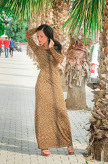Brunette girl in a long leopard dress