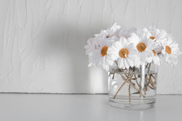 white chrysanthemums in a transparent vase on a table