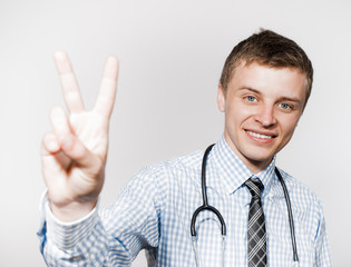 Fototapeta premium Portrait of a handsome medical doctor showing you victory sign