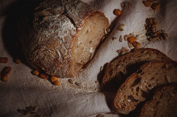 pane fatto in casa con chicchi di granturco e girasole su canovaccio grezzo bianco spolverato di farina di segale