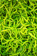 fresh thin hot green peppers laid out on the counter for sale in the organic market