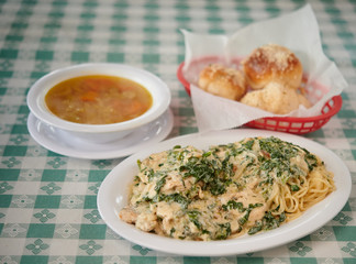 Lemon chicken on white plate soup and garlic rolls selective focus