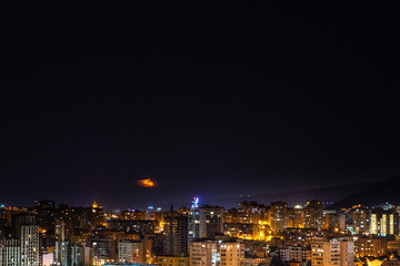 Moon rising and stars in night sky over Tbilisi