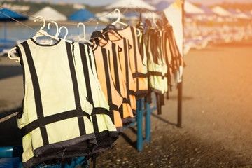 old shabby lifejackets hanging on the beach by the tent with extreme water hire
