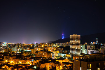 Fototapeta na wymiar Moon rising and stars in night sky over Tbilisi