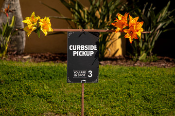 Brightly decorated curbside pick up sign at restaurant