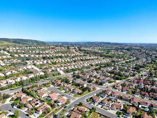 Obraz na płótnie Canvas Aerial view of upper middle class neighborhood with residential subdivision mansion and swimming pool during with blue sky in San Diego, California, USA.