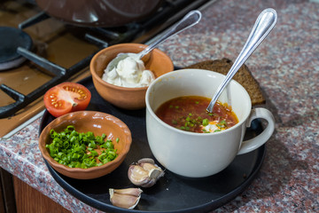 Cooking of borscht. A bowl with borscht on a table.