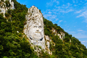 Fototapeta na wymiar The face of the Dacian king Decebal is a 55 m high bas-relief located on the rocky bank of the Danube, between the towns of Echelnita and Dubova, near the city of Orsova, Romania.