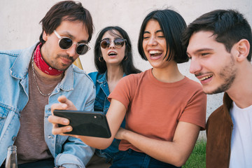 Group of friends watching something in smartphone.