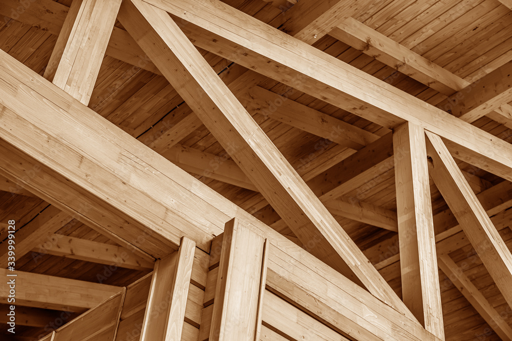 Wall mural the construction of the wooden roof. detailed photo of a wooden roof overlap construction.