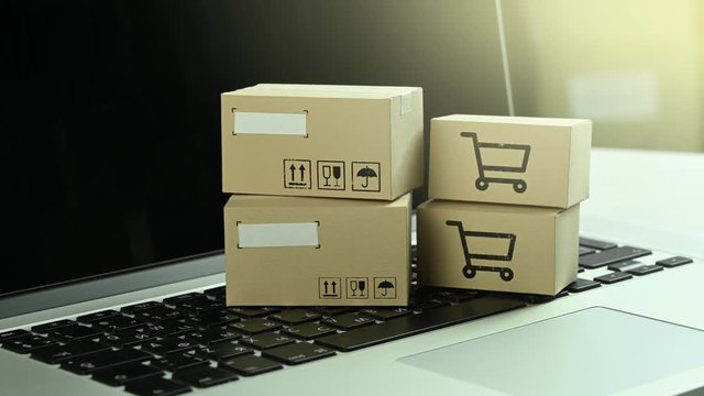 cardboard parcels stand on a laptop keyboard. Online shopping concept
