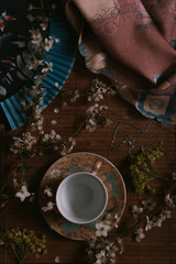 tea cup with flowers and blooming  branch on wooden background