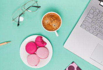 Laptop, macarons and cup of coffee flat lay.