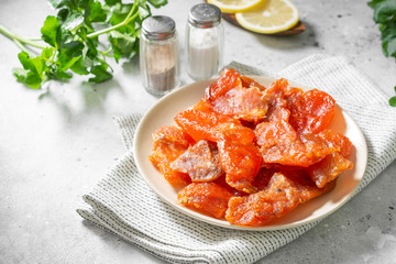 Dried macrourus caviar in a white plate on a light gray table. Dried or dried caviar. Healthy diet