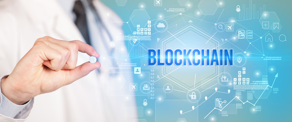 Doctor giving a pill with BLOCKCHAIN inscription, new technology solution concept