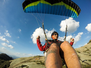 paraglider pilot flying over Brazilian mountains