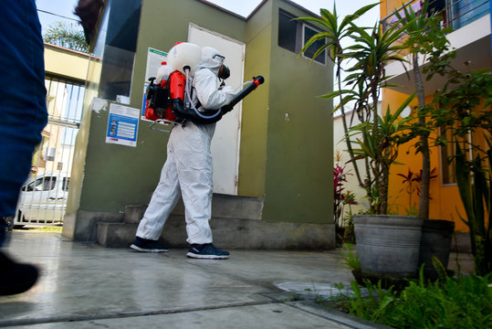 person wearing medical protective clothing  fumigate to prevent the spread of  coronavirus in streets of lima-Peru