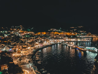 Obraz premium Aerial panoramic cityscape view of Parga city, Greece during the Summer. Beautiful architectural colorful buildings illuminated at night and night traffic near the port of Parga Epirus, Greece, Europe
