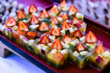 Close up of healthy and fresh seasonal little portion.  cakes with strawberry and other fruits for wedding or party catering job - colorful food background image