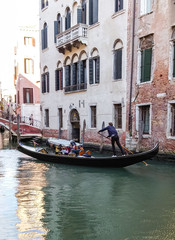 Naklejka na ściany i meble Water channels of Venice city. Gondolier rolls tourists on the gondola on Grand Canal in Venice, Italy.