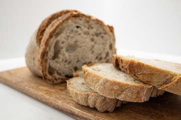 freshly cut homemade bread on a wooden board.
