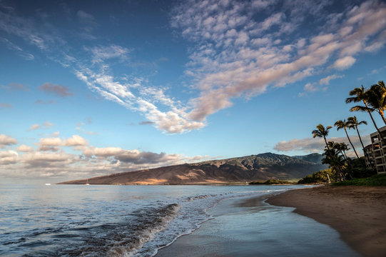 Dramatic image of Sugar beach with waves washing ashore and sky in Maui, Hawaii in the town of Kihei