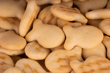 Texture of salted crackers. Close up of cookies in form of fish. Concept of background for your text.