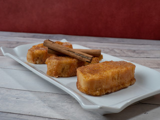 three french toast with cinnamon on white plate and light background