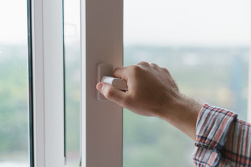 Male hand opens a window