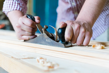 carpenter working  with  plane  on wooden background
