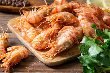Shrimp on a wooden Board on a brown wooden table. Greenlandic prawns