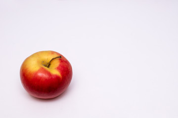 a single red and yellow Apple is located in the lower-left corner of the white background with space for text