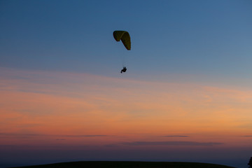 Paragliding silhouette flying at sunset, Brazil