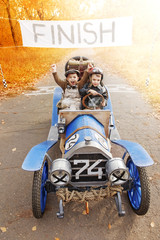 Young racer and mechanic on old race car