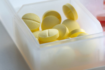 closed-up  yellow pills In white transparency plastic pill box