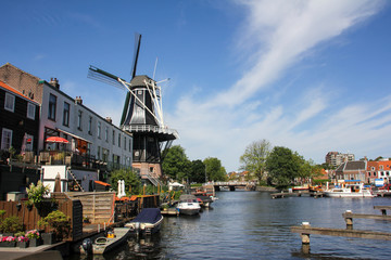 Fototapeta na wymiar Haarlem harbor with boats and a dark background mill