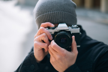 thoughtful male photographer with a camera on street