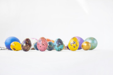 On a white background are painted eggs. Real hand-painted eggs. A multi-faceted photo. Holiday and joy of Bright Easter for the whole family