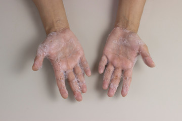 Fototapeta premium Overhead shot of washing hands with soap to keep germs away and for prevention of coronavirus, co-vid 19 diseases from spreading on white background
