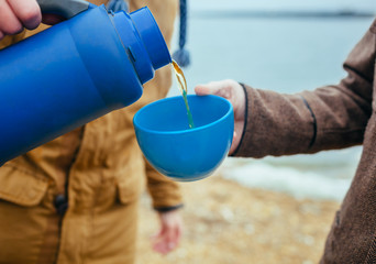 Man pouring tea at outdoors in autumn