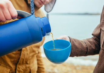 Man pouring tea at outdoors in autumn